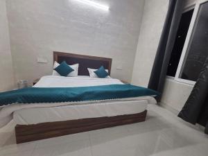 a bedroom with a large bed with blue pillows at Deep Heritage Hotel & Restaurant in Phata +5 photos