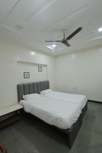 a bedroom with a bed and a ceiling fan at Hotel Keshav Pride in Dhule