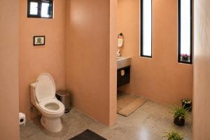 a bathroom with a toilet and a sink at Simple Stay, Big Views, Private Room & Pool in Todos Santos