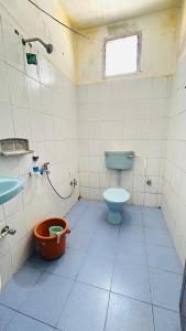a bathroom with a blue toilet and a sink at Valley homes in Ooty