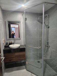 a man taking a picture of a bathroom with a shower at Sora Hotel in Thường Son +3 photos