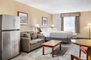 a hotel room with a bed and a refrigerator at Quality Inn Airport in Moncton