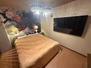 a bedroom with a bed and a painting on the wall at ホテル 天使と悪魔 in Gobō