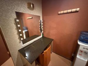 a bathroom with a sink and a mirror at ホテル 天使と悪魔 in Gobō
