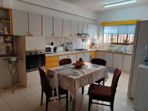 a kitchen with a table and chairs and a table and a kitchen with at Shared Top 1st floor villa in Limassol