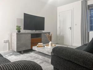 a living room with a tv and a couch at Spring Gardens in Lower Darwen