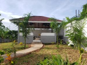a small white house with a red roof at Casa Marabella C3 in Diani Beach