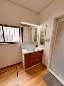 a bathroom with a sink and a mirror at Glad Kasuga in Kasugabaru +36 photos