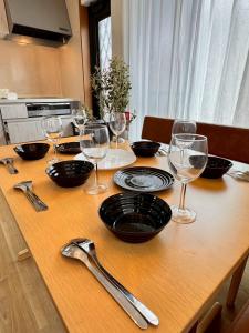 a table with wine glasses and plates on it at Glad Kasuga in Kasugabaru