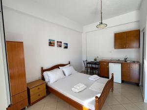 a small bedroom with a bed and a kitchen at Rexhos Studios in Himare