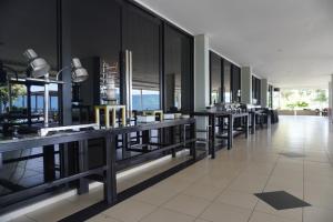 a lobby with tables and windows in a building at Patra Parapat Hotel in Sibagading