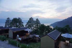 a group of buildings with a view of a lake at Patra Parapat Hotel in Sibagading