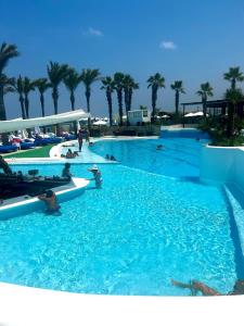 a large swimming pool with people in the water at Riviera Hotel and Beach Lounge, Beirut in Beirut +92 photos