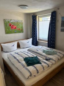 a bedroom with a bed with blue curtains and a window at Haus Wünsche in Wieck