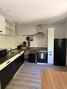 a kitchen with a black refrigerator and a stove at Hermelsstübche in Siegen