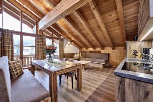 a kitchen and living room with a wooden ceiling at Ferienhaus Magdalena in Mittenwald