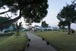 a park with a playground with slides and swings at Patra Parapat Hotel in Sibagading