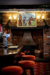 a bar with paintings of horses on the wall at The Belfry, Littldean in Little Dean