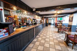 a restaurant with a bar and some tables and chairs at The Belfry, Littldean in Little Dean