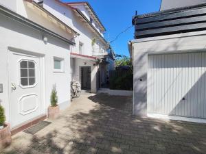 a white house with a garage and a driveway at Fair-Hostel in Darmstadt