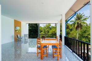 a dining room with a table and chairs on a balcony at Ck Home Lanta in Phra Ae beach