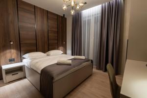 a bedroom with a large bed and a chandelier at Boutique Hill Hotel in Požarevac +58 photos