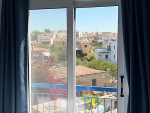 a window with a view of a city at Hotel Avra in Egina +72 photos