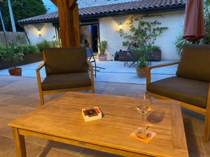 a coffee table with a glass of wine on a patio at La Maison du Parc in Saint-Vite