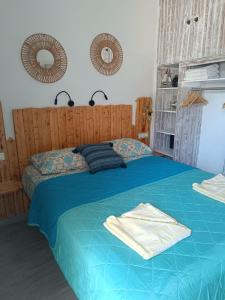 a bedroom with a blue bed with two mirrors at Sea Sound Haraki apartment in Haraki
