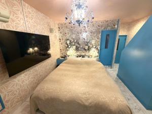 a bedroom with a large bed and a chandelier at ホテル 天使と悪魔 in Gobō