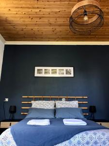 a bedroom with a blue bed with a blue wall at A l'ombre du Fort in Fuilla