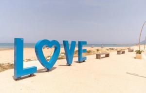a sign that says love on the beach at 1 Bedroom Beautiful Apartment In Trappeto in Trappeto