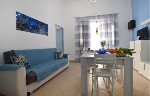 a living room with a blue couch and a table at 1 Bedroom Beautiful Apartment In Trappeto in Trappeto