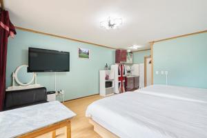a bedroom with two beds and a flat screen tv at Heidi Korea in Hongcheon