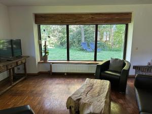 a living room with a large window and a couch and a table at Haus Tersteegen in Oberbrombach