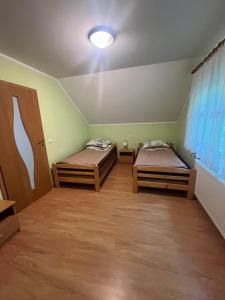 two beds in a room with green walls at Holiday house EWA in Meszna Opacka +45 photos