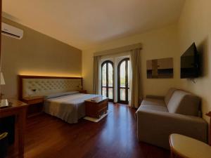 a hotel room with a bed and a couch at Hotel Del Corso in SantʼAntìoco