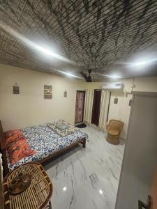 a room with a bed and a table in it at Richard's Homestay -Classy AC Rooms in Thiruvalla +3 photos