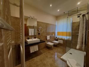 a bathroom with a sink and a toilet and a shower at Hotel Del Corso in SantʼAntìoco +26 photos