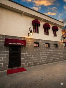 a brick building with red awnings and a sign on it at Grand Sur Butik Otel in Diyarbakır