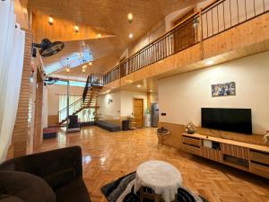 a living room with a television and a staircase at Oak & Amber Retreat in Manāli