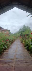 a stone path with red flowers on the side at The Kiran's Resort Pench in Khawāsa +7 photos