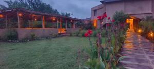 a house with a garden with red flowers in the yard at The Kiran's Resort Pench in Khawāsa