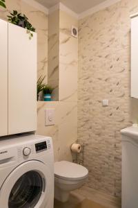a bathroom with a washing machine and a toilet at Modern 2BR Balcony View Pipera in Voluntari +17 photos