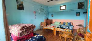 a room with blue walls and a table and a couch at Far out Homestay in Hawālbāgh
