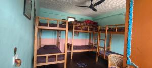 a room with four bunk beds in a house at Far out Homestay in Hawālbāgh