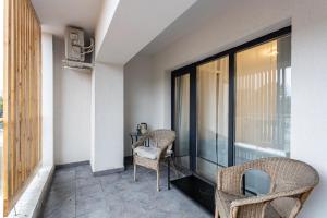 a balcony with two chairs and a table at Modern 2BR Balcony View Pipera in Voluntari