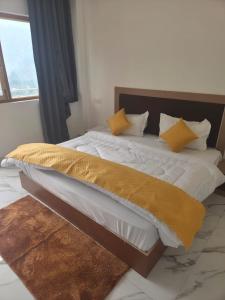 a bedroom with a large bed with yellow pillows at Deep Heritage Hotel & Restaurant in Phata