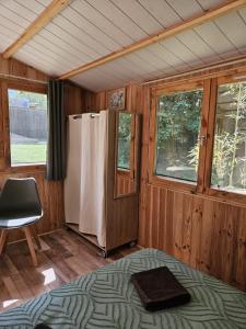 a room with a refrigerator and a chair in it at Chalet La Savane in Le Gond