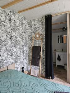 a bedroom with a bed and a wall at Chalet La Savane in Le Gond